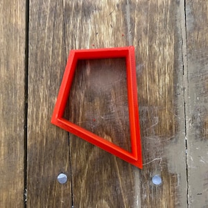 May include: A bright red plastic cookie cutter shaped like a diamond.