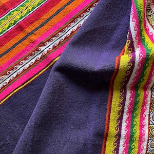 Small, hand woven wool rug from Peru. Purple ground, bright stripes. Fading on one side.