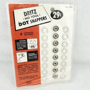 May include: A package of Dritz No. 655 Dot Snappers containing 8 complete metal fasteners. The packaging is orange and white with black text, featuring instructions for the patented arrow head points and listing various garment applications.