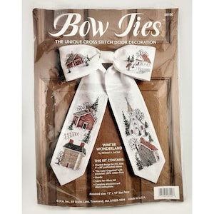 May include: A cross-stitch kit for a door decoration shaped like a bow tie. The design features winter scenes with houses and a church. The kit includes charted design, ribbon, floss, needle, and instructions. Finished size is 11" x 17".