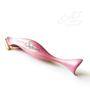 Könnte beinhalten: Ein rosa Holz-Kalligraphie-Stift mit einer goldenen Feder. Der Stift ist mit dem Namen "Sabrina" graviert.