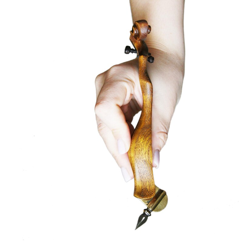 Puede incluir: Una pluma de caligraf&iacute;a de madera con un mango de madera marr&oacute;n y una punta de oro. La pluma tiene forma de viol&iacute;n.