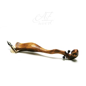 Puede incluir: Una pluma de caligraf&iacute;a de madera con una punta de lat&oacute;n y un dise&ntilde;o de rollo decorativo en el extremo. La pluma est&aacute; hecha por AZ Wood.