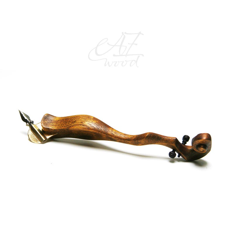 Puede incluir: Una pluma de caligraf&iacute;a de madera con una punta de lat&oacute;n y un dise&ntilde;o de rollo decorativo en el extremo. La pluma est&aacute; hecha por AZ Wood.
