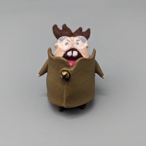 May include: A brown 3D printed figurine of a cartoon character wearing a brown coat, glasses, and a surprised expression.
