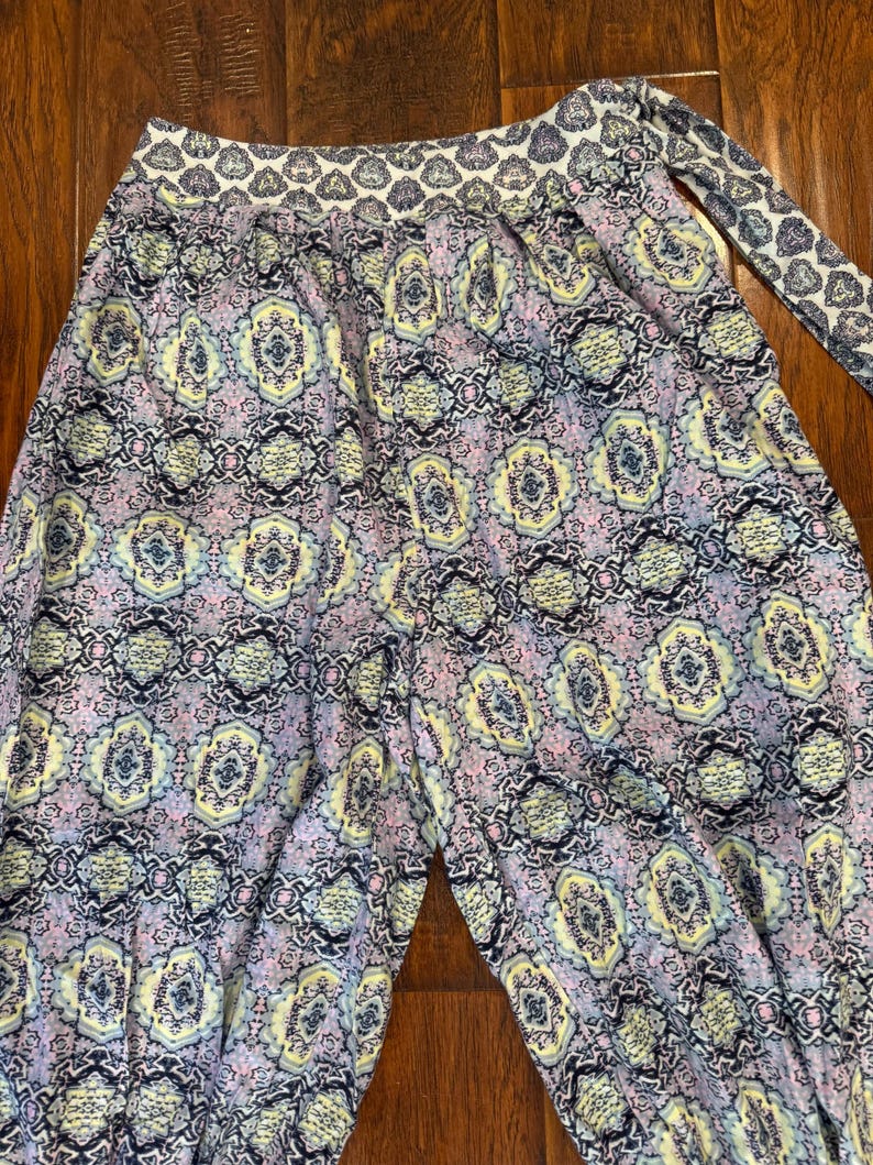 K&ouml;nnte beinhalten: Gemusterte Hose mit sich wiederholendem Design in Lavendel-, Gelb- und Marineblaut&ouml;nen. Der Bund und die Bindung weisen ein kontrastierendes Muster auf. Die Hose ist aus leichtem Stoff gefertigt.