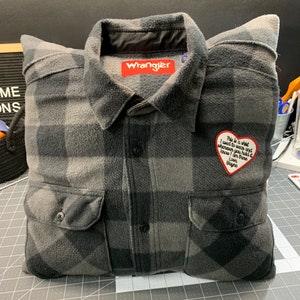 May include: A gray and black plaid flannel shirt pillow with a red heart-shaped patch that says "This is a shirt I want to wear and whenever you hold it know I am there. Love, Wayne."