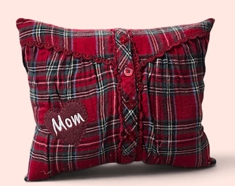 May include: A rectangular throw pillow featuring a red, green, and white plaid pattern. The pillow has a vertical button placket with four red buttons and a decorative lace trim. A dark red heart-shaped patch with the white embroidered text Mom.