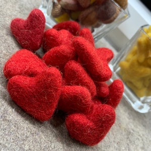 May include: A pile of red felt hearts. The hearts are soft and fuzzy and are ideal for crafts or decorations.