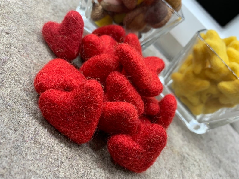 May include: A pile of red felt hearts. The hearts are soft and fuzzy and are ideal for crafts or decorations.