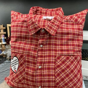 May include: Red and white plaid pillow with a heart-shaped patch that says "You are the reason I need to believe in magic you make me smile even when I'm sad Love, Mom".