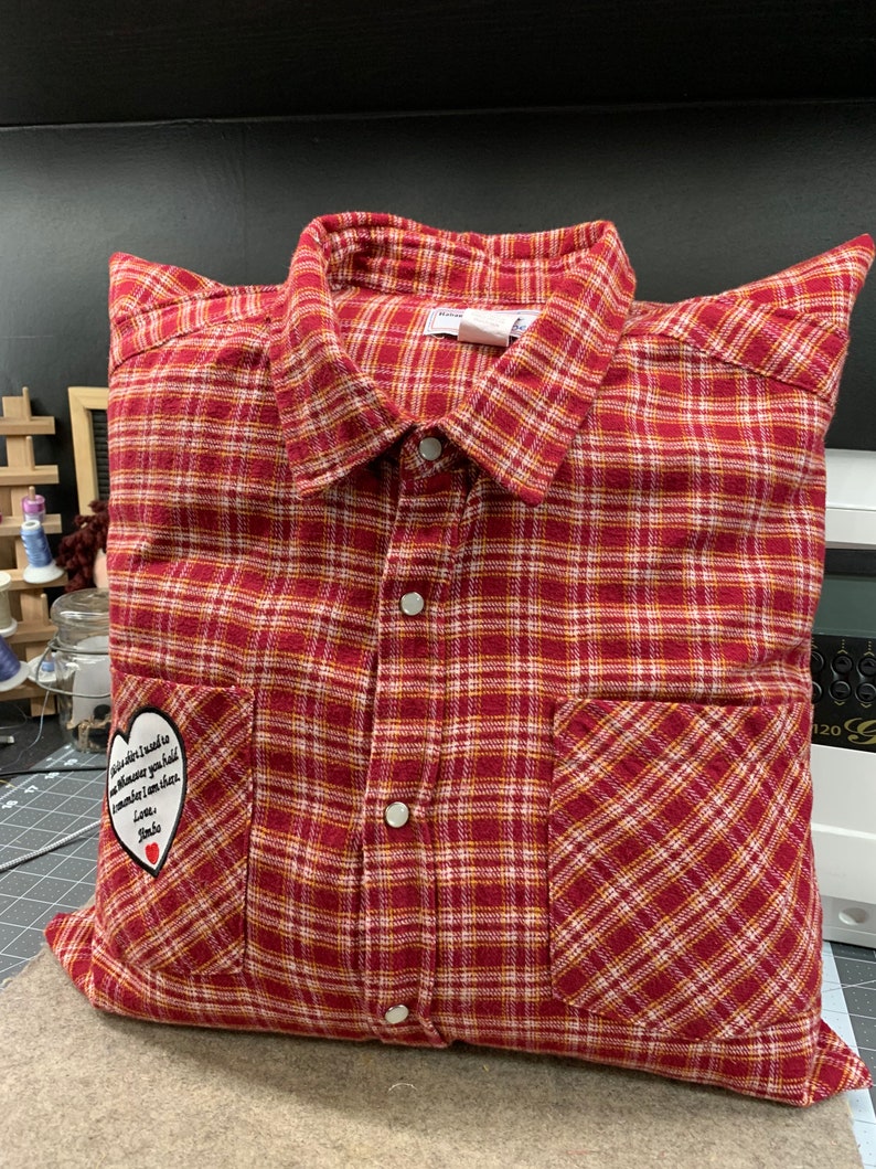 May include: Red and white plaid pillow with a heart-shaped patch that says "You are the reason I need to believe in magic you make me smile even when I'm sad Love, Mom".