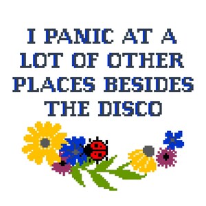 Op de afbeelding: Een kruissteekontwerp met een bloemstuk met gele, blauwe en paarse bloemen, een rode lieveheersbeestje en groene bladeren. De tekst "I panic at a lot of other places besides the disco" staat in blauwe letters boven de bloemen.