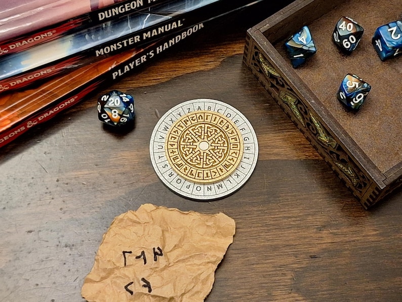 May include: A tabletop gaming scene featuring a wooden box with dice, a circular cipher, a 20-sided die, and a crumpled paper with symbols. Books with "Dungeons & Dragons" and "Monster Manual" are in the background. The cipher is gold and white.