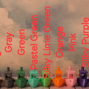 Puede incluir: Una fila de 20 peque&ntilde;os barcos de juguete coloridos, cada uno con un color y dise&ntilde;o diferente. Los barcos est&aacute;n dispuestos en una l&iacute;nea de izquierda a derecha, con los colores negro, azul, azul hielo, azul claro, marr&oacute;n, azul claro, gris, verde, verde pastel, verde lima, naranja, rosa, morado sedoso, morado pastel, arco&iacute;ris, rojo, oro rosa, blanco y amarillo.