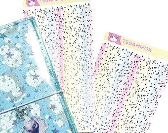 Puede incluir: Dos hojas de papel adhesivo transparente con puntos negros y una agenda azul claro con un patrón de estrellas blancas y azules. El papel adhesivo tiene el texto "TEGAMIFOX" impreso.