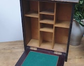 A vintage ebonised pigeonhole unit with drop down front.