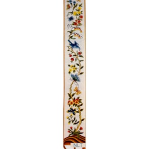 May include: A long, narrow, vertical decorative panel featuring a painted design of a winding vine with green leaves, various colorful flowers, butterflies, and a blue bird. The base of the panel shows a brown mound with the letters NLT printed.