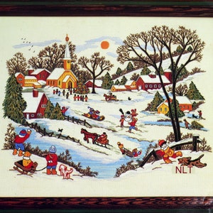 May include: Embroidered winter scene depicting a snowy village with a church, houses, and people sledding and building a snowman. The artwork features a brown wooden frame and a vibrant color palette of red, yellow, and blue.