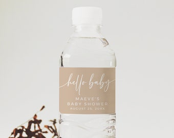 Könnte beinhalten: Ein braunes Wasserflaschenetikett mit weißem Text, der "hello baby", "Maeve's Baby Shower" und "August 25, 20XX" lautet.