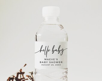Könnte beinhalten: Eine weiße Wasserflasche mit einem Etikett, auf dem "hello baby" in schwarzer Schrift steht. Das Etikett enthält auch den Text "Maeve's Baby Shower August 25, 20XX".