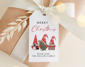 Pode incluir: Um presente embrulhado em papel castanho com uma fita branca e uma etiqueta decorativa. A etiqueta diz "MERRY Christmas" com ilustrações de gnomos e o texto "WITH LOVE, THE HOLLINS FAMILY".