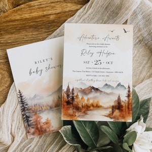 Könnte beinhalten: Eine Babyparty-Einladung mit einer Aquarell-Illustration einer Bergkette, eines Flusses und Bäumen in Braun-, Orange- und Grüntönen. Der Text lautet "Adventure Awaits" und "Riley's Baby Shower".