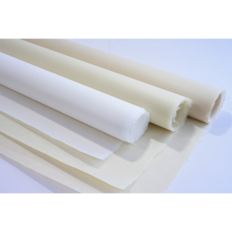 May include: Four rolls of white and off-white paper, stacked on top of each other. The paper is textured and has a natural, handmade look.