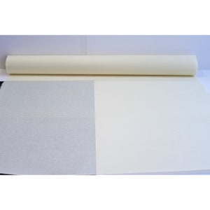 May include: A roll of white paper with a textured surface. The paper is unrolled to show the difference in texture between the two sides.