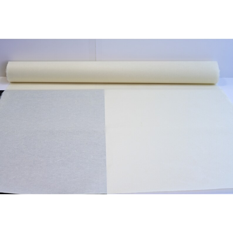 May include: A roll of white paper with a textured surface. The paper is unrolled to show the difference in texture between the two sides.