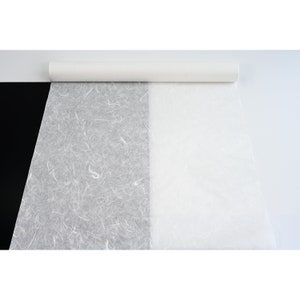 K&ouml;nnte beinhalten: Eine Rolle wei&szlig;es, strukturiertes Papier mit einer glatten wei&szlig;en Seite. Das Papier ist teilweise abgewickelt und zeigt die strukturierte Seite.