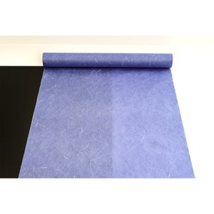 K&ouml;nnte beinhalten: Eine Rolle blaues Seidenpapier mit einer strukturierten, faserigen Oberfl&auml;che. Das Papier ist aufgerollt und teilweise abgewickelt, wodurch die blaue Farbe und die Textur sichtbar werden.