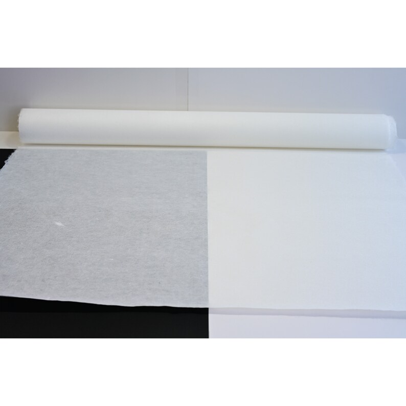 May include: A roll of white paper, unfurled to show the texture of the paper. The paper is smooth and white.
