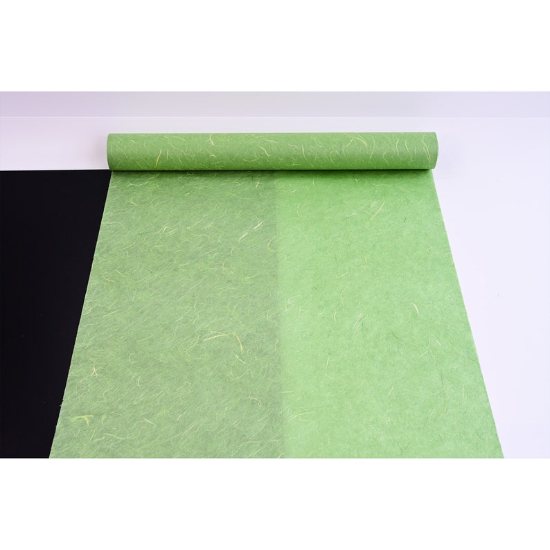 K&ouml;nnte beinhalten: Eine Rolle gr&uuml;nes Seidenpapier mit einer dezenten Textur. Das Papier ist abgewickelt und hat eine hellgr&uuml;ne Farbe.