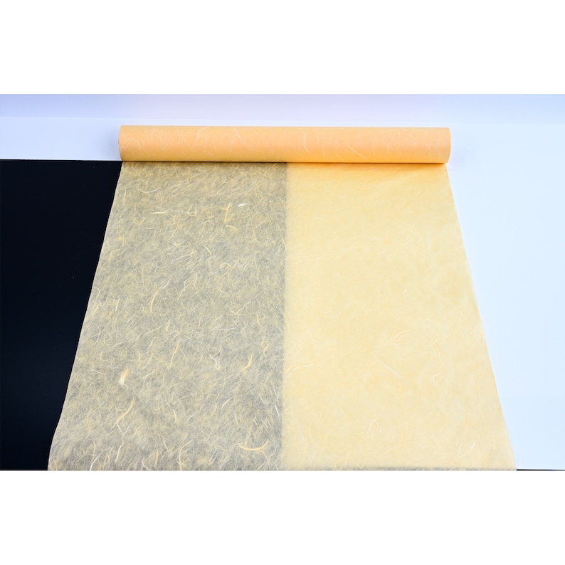 K&ouml;nnte beinhalten: Eine Rolle hellgelbes Seidenpapier mit einer strukturierten Oberfl&auml;che. Das Papier ist abgewickelt und teilweise aufgerollt.