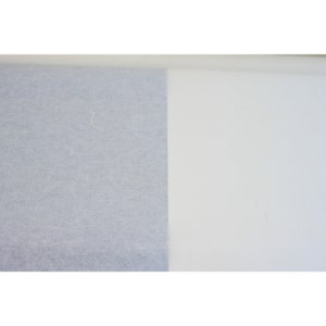 May include: A close-up of two different types of paper. The left side of the image shows a light gray textured paper. The right side of the image shows a white smooth paper.