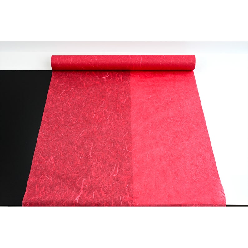 K&ouml;nnte beinhalten: Eine Rolle rotes Seidenpapier mit einer strukturierten Oberfl&auml;che. Eine Seite des Papiers hat eine ausgepr&auml;gtere Struktur als die andere.