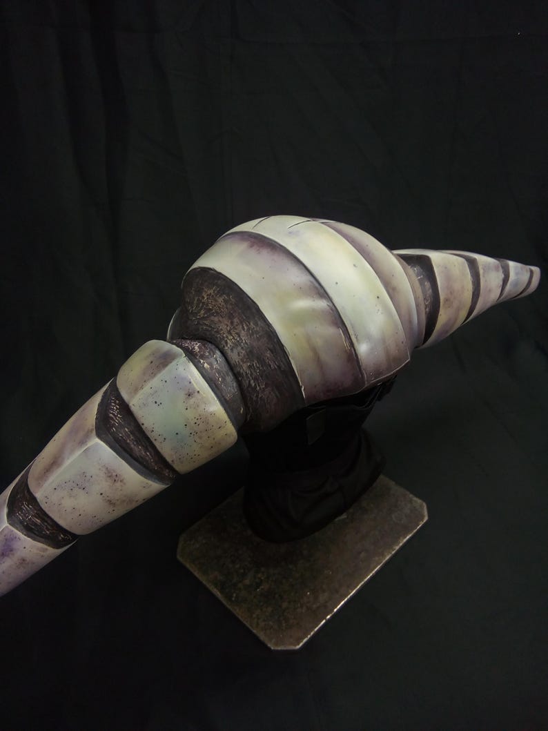 May include: A detailed, hand-painted, gray and white striped, ceramic sculpture of a creature with a long, curved, segmented body. The sculpture is mounted on a metal base.
