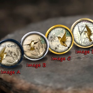 May include: Four round, gold-rimmed, glass cabochons with images of hummingbirds on vintage postcards. The postcards feature the text "Post Card" and other handwritten text. The cabochons are labeled "Image A", "Image B", "Image C", and "Image D".
