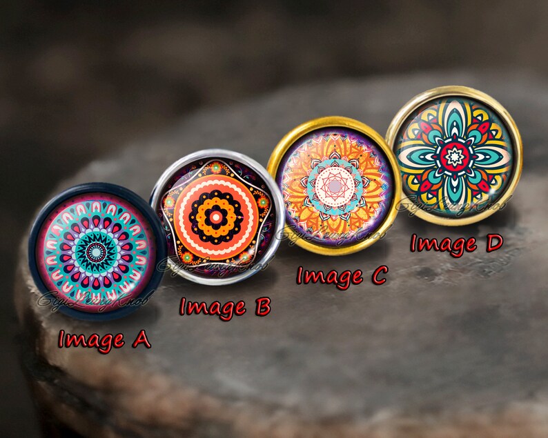 Peut inclure: Quatre cabochons ronds, color&eacute;s et d&eacute;coratifs avec des motifs de mandalas. Les cabochons sont sertis dans des montures argent&eacute;es et dor&eacute;es. Les motifs pr&eacute;sentent une vari&eacute;t&eacute; de couleurs, notamment le rouge, l'orange, le jaune, le vert, le bleu et le violet.