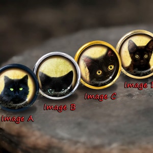 Op de afbeelding: Vier ronde zwarte en gouden knoppen met afbeeldingen van zwarte katten met groene ogen. De knoppen zijn gelabeld Image A, Image B, Image C en Image D.