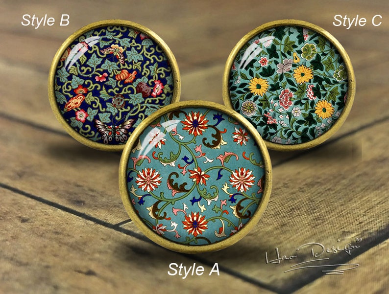 May include: Three round, decorative, brass-coloured knobs with different floral patterns. The knobs are labelled "Style A", "Style B", and "Style C".