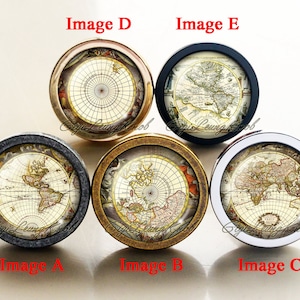 Op de afbeelding: Vijf ronde kastknoppen met verschillende kleuren frames en vintage wereldkaartontwerpen. De knoppen zijn gemaakt van metaal en hebben een gepolijste afwerking.