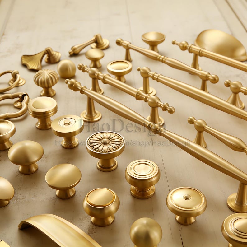 May include: A collection of various brass cabinet hardware, including knobs and pulls. The hardware features a range of designs, from simple round knobs to ornate pulls with decorative detailing. The brass finish gives the hardware a warm, classic look.