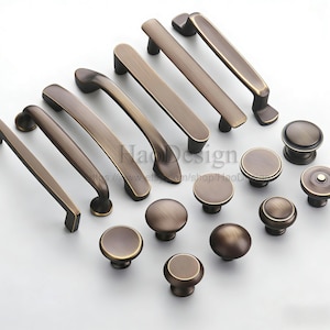 May include: A selection of bronze-coloured cabinet hardware, featuring a range of handle styles and round knobs. The handles include straight bars and curved pulls. The knobs have a simple, rounded design. All pieces have a vintage aesthetic.
