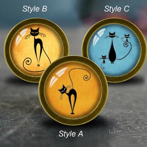Könnte beinhalten: Drei runde Knöpfe mit bronzefarbenen Rändern, jeweils mit einem schwarzen Katzendesign. Die Hintergründe sind gelb oder blau. Die Knöpfe sind mit "Style A", "Style B" und "Style C" beschriftet. Die Signatur des Künstlers befindet sich unten rechts.