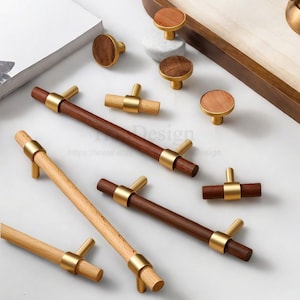 May include: A collection of wooden cabinet knobs and pulls with brass accents. The knobs have a round, flat wooden top. The pulls are rectangular with a wooden center and brass ends. Some pulls are light wood, others are dark wood.