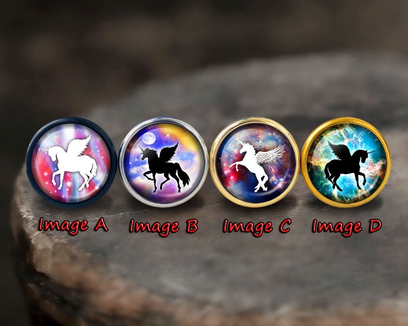 May include: Four round glass cabochons with different coloured backgrounds and a white or black winged unicorn silhouette. The cabochons are set in silver, gold, and black metal settings.