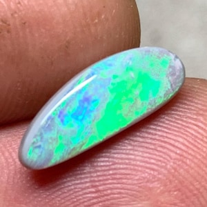 May include: A white ceramic mug with a black handle and the text "But First, Coffee" in a bold, black font. The mug is set against a blurred background, suggesting a cosy setting.