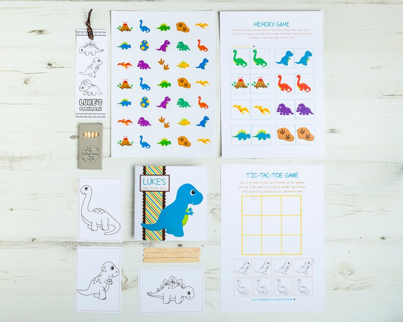 May include: A set of dinosaur-themed party games for kids. The set includes a memory game, a tic-tac-toe game, coloring pages, and stickers. The games are printed on white cardstock and feature colorful illustrations of dinosaurs.